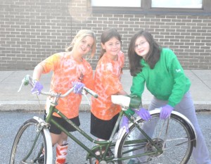 From left, Samantha Scott, Jordan Hower and Meghan Berry, all of East Marlborough, work to clean up a donated bike. Dozens of kids and adults gathered Saturday to work on the donated bikes at Patton Middle School.